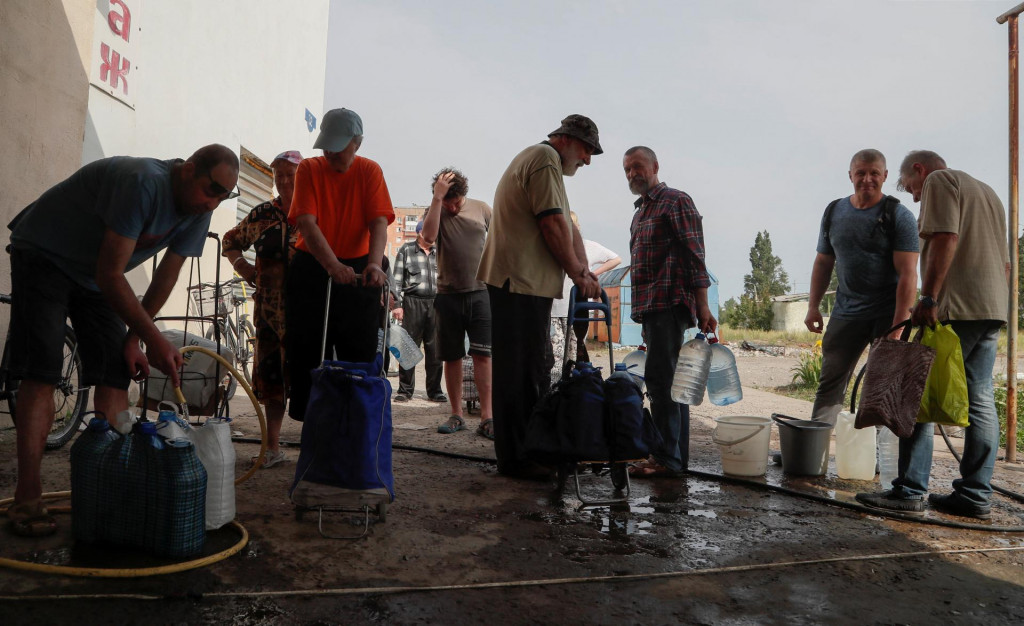 Miestni obyvatelia sa zhromažďujú, aby si nabrali vodu počas ukrajinsko-ruského konfliktu v meste Rubižne v Luhanskej oblasti na Ukrajine. FOTO: Reuters
