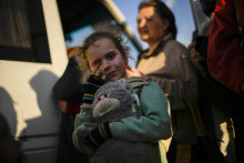 Dievča a jej rodinní príslušníci, ktorí utiekli z ukrajinského obliehaného prístavného mesta Mariupol. FOTO: TASR/AP



