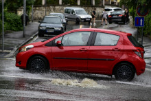 Auto prechádza po zaplavenej ceste počas silného dažďa v Bratislave. FOTO: TASR/ Pavol Zachar