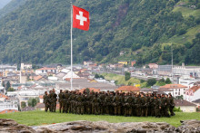 &lt;p&gt;Vojaci v blízkosti švajčiarskej vlajky. FOTO: Reuters&lt;/p&gt;