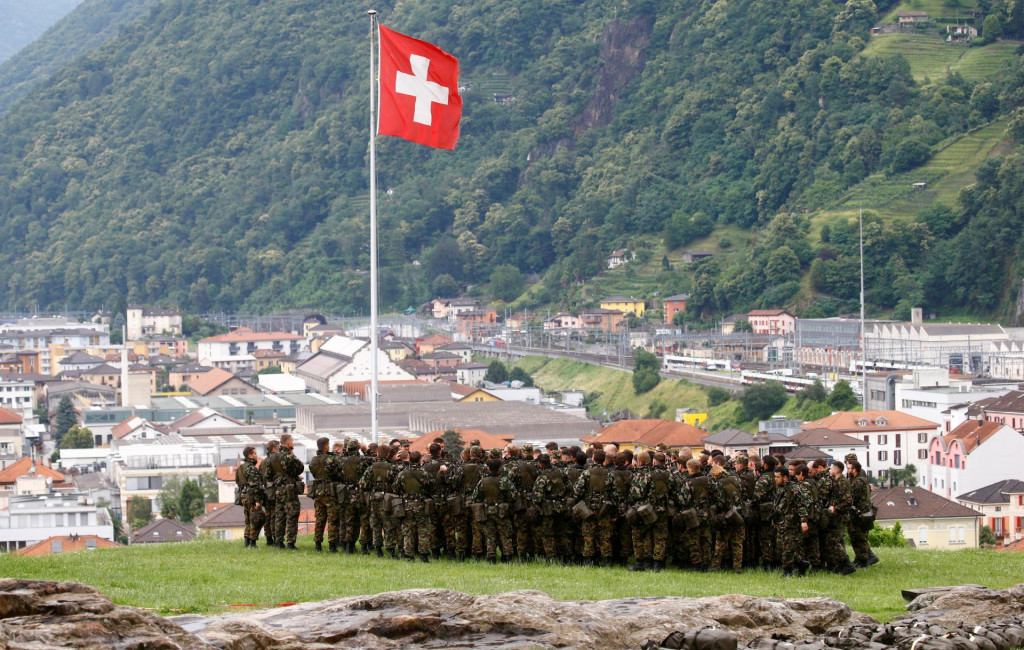 Vojaci v blízkosti švajčiarskej vlajky. FOTO: Reuters