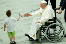 Pápež František sa rozpráva s dieťaťom na stretnutí s vojakmi talianskej armády vo Vatikáne. FOTO: REUTERS

