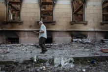 Miestny muž kráča vedľa budovy poškodenej vojenským útokom v meste Lysyčansk. FOTO: REUTERS