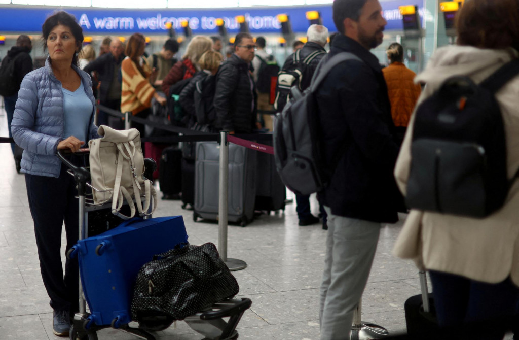 Cestujúci stoja v rade na odbavenie na letisku Heathrow Terminal 5 v Londýne. FOTO: Reuters