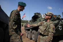 Poľskí a americkí vojaci stoja pri svojich obrnených vozidlách počas vojenského cvičenia jednotiek NATO. FOTO: Reuters