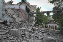 &lt;p&gt;Záchranári a miestni obyvatelia vyťahujú mŕtve telo spod trosiek budovy v meste Lysyčansk, v Luhanskej oblasti. FOTO: TASR/AP&lt;/p&gt;