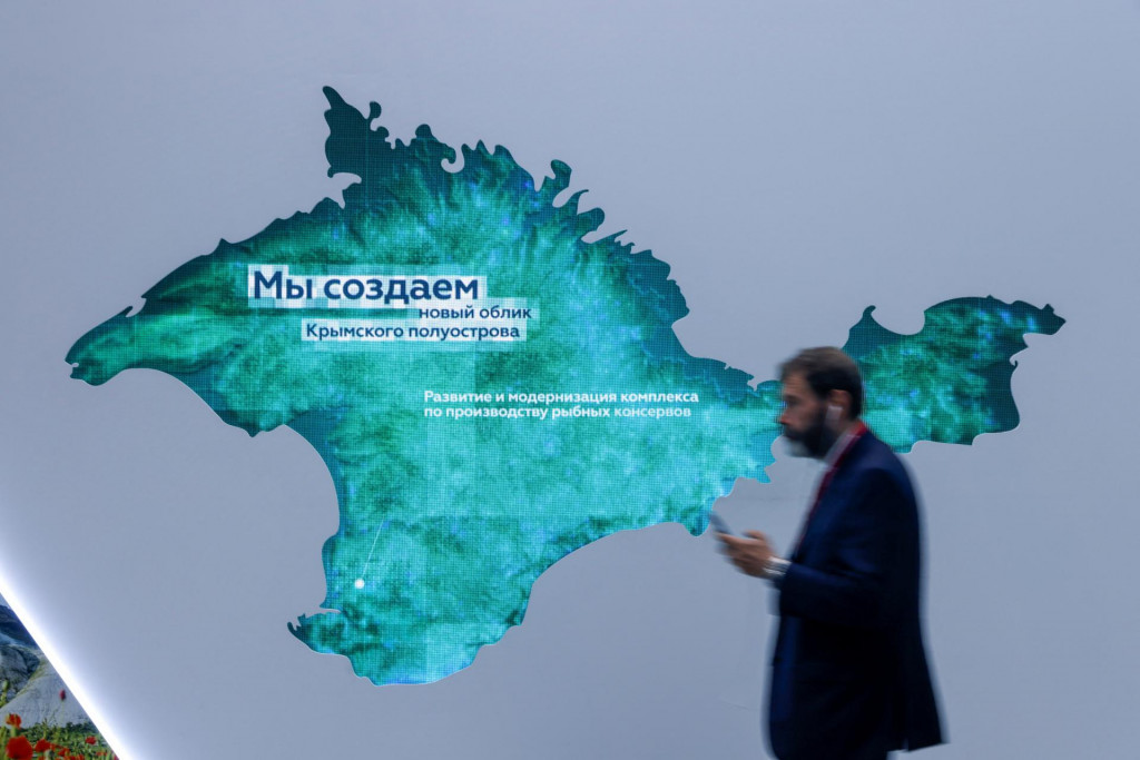 Účastník prechádza okolo stánku s mapou Krymského polostrova na St. Petersburg International Economic Forum. FOTO: REUTERS/Maxim Shemetov