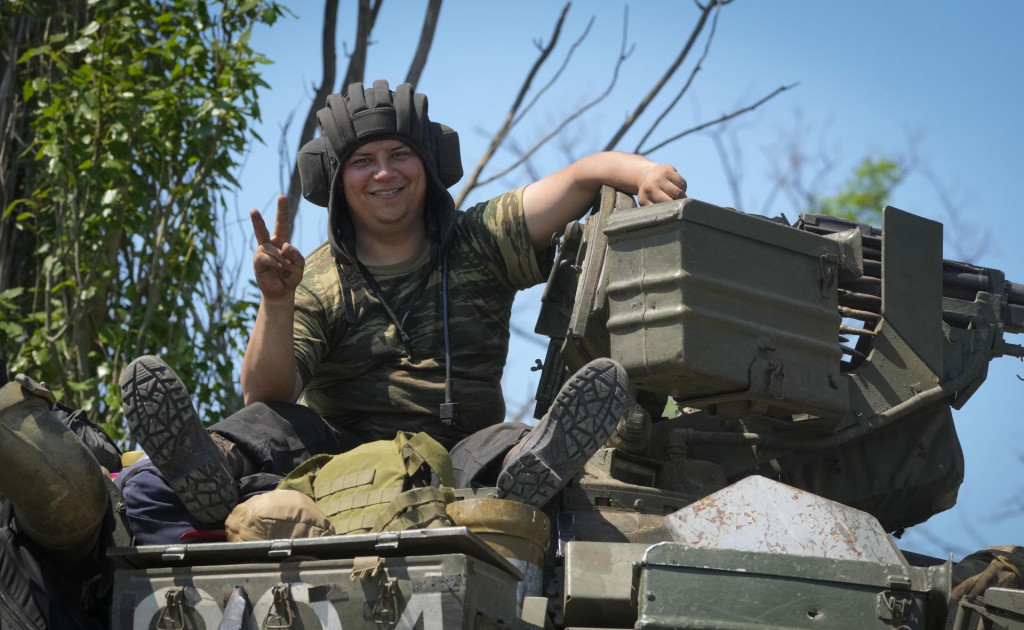 Ukrajinský vojak sa usmieva a ukazuje znak víťazstva z tanku v Doneckej oblasti. FOTO: TASR/AP