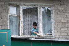 &lt;p&gt;Chlapec odstraňuje rozbité sklo z rámu okna po ostreľovaní v meste Doneck, v samozvanej Doneckej ľudovej republike na východe Ukrajiny. FOTO: TASR/AP&lt;br /&gt;
&lt;br /&gt;
&lt;br /&gt;
 &lt;/p&gt;
