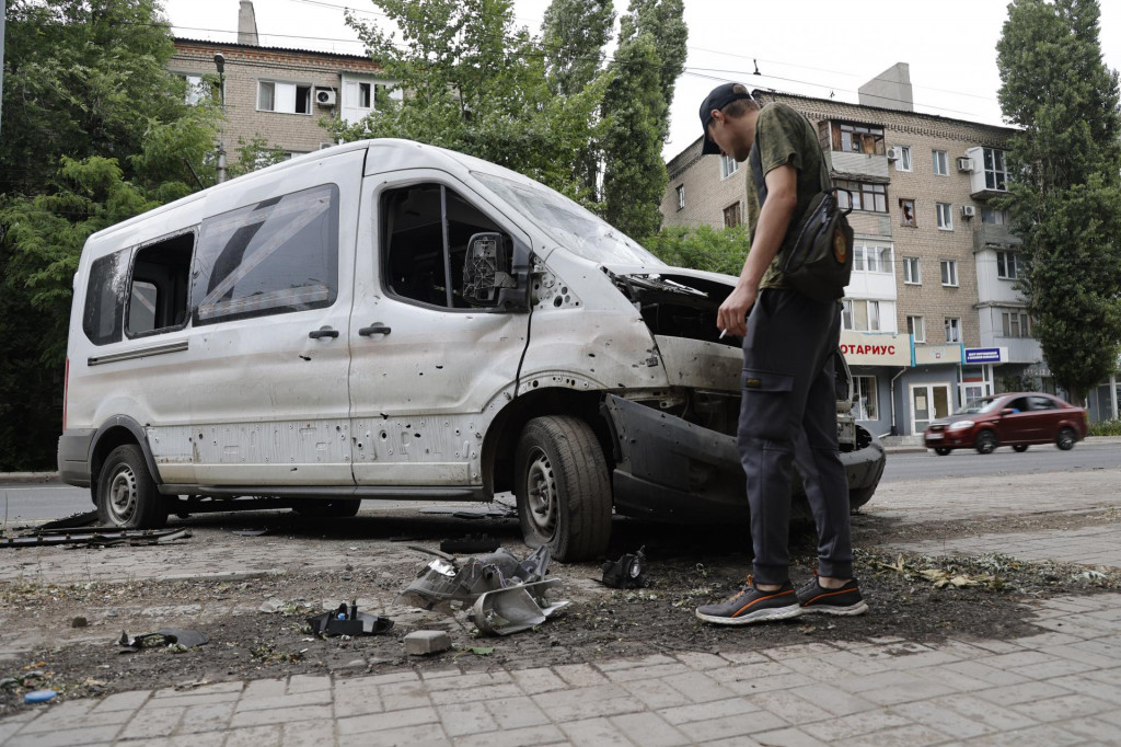 Muž kontroluje auto zničené počas ostreľovania v meste Doneck, v samozvanej Doneckej ľudovej republike. FOTO: TASR/AP