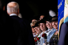 Ľudia v tradičnom bavorskom oblečení vítajú amerického prezidenta Joea Bidena pri jeho príchode na summit G7. FOTO: Reuters 