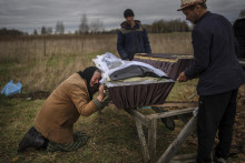 Matka plačúca pri trhle svojho syna na Ukrajine. FOTO: TASR/AP