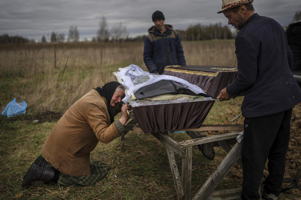Matka plačúca pri trhle svojho syna na Ukrajine. FOTO: TASR/AP