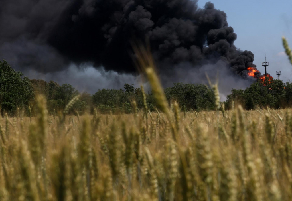 V pozadí požiar na plynovom zariadení v Charkovskej oblasti na Ukrajine. FOTO: Reuters