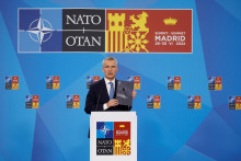 Generálny tajomník NATO Jens Stoltenberg vystavuje brožúru Strategickej koncepcie počas svojej tlačovej konferencie na summite NATO. FOTO: Reuters