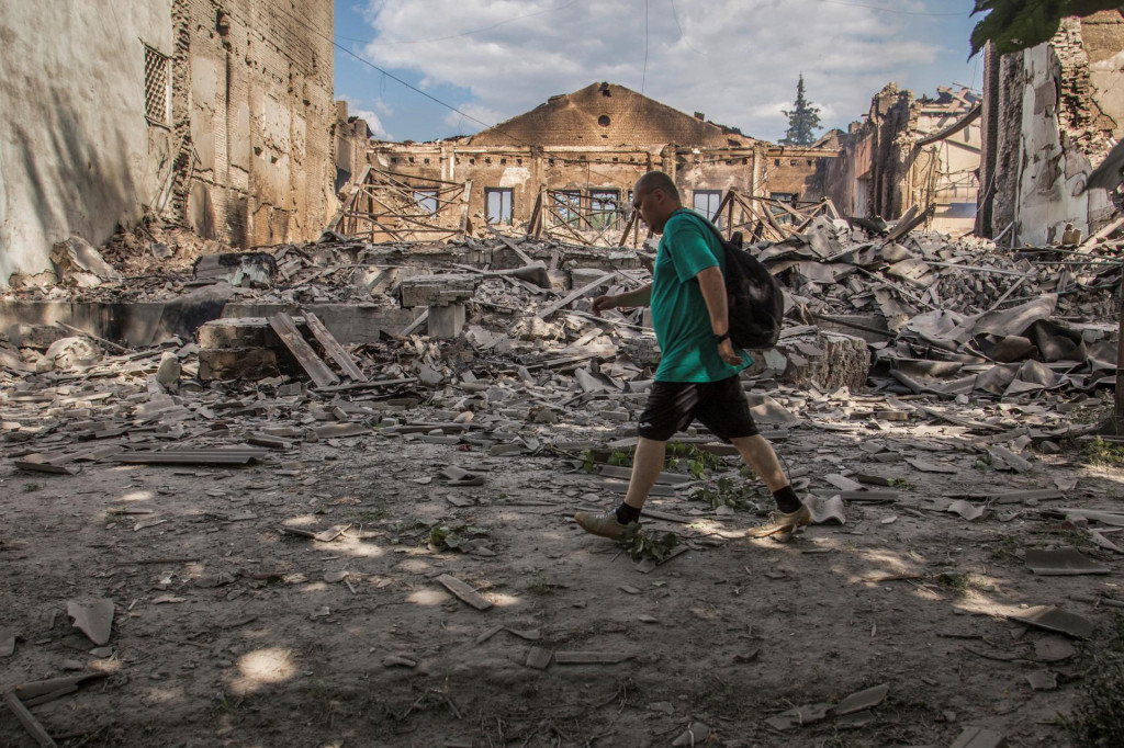Miestny obyvateľ kráča pred zničenou budovou v meste Lysyčansk. FOTO: Reuters