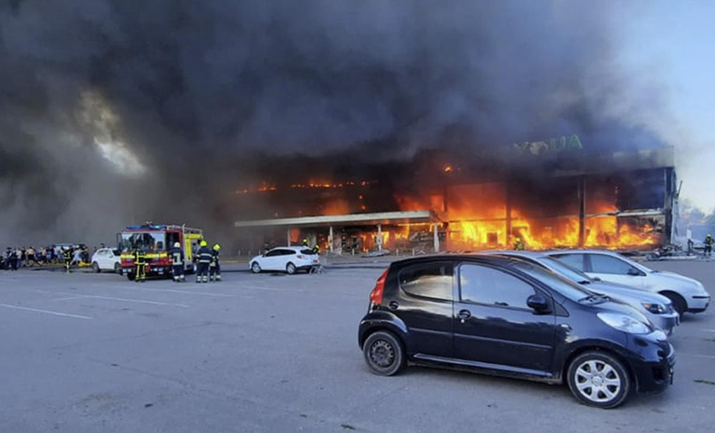 Hasiči pracujú na hasení požiaru v obchodnom centre, ktoré vyhorelo po raketovom útoku v Kremenčuku na Ukrajine v pondelok. FOTO: TASR/AP