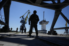 Ruský vojak stráži oblasť prístavu v Mariupole na Ukrajine, ktorý nedávno začal fungovať po ťažkých bojoch. FOTO: TASR/AP
 