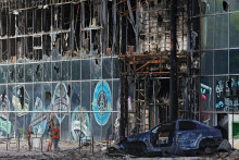 Miestni obyvatelia stoja vedľa budovy zničenej počas ukrajinsko-ruského konfliktu v meste Lysyčansk. FOTO: Reuters 