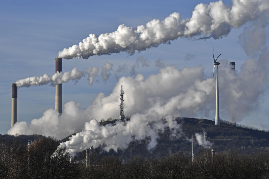Uhoľná elektráreň a veterná turbína v Gelsenkirchene. Nemecko je najväčším producentom hnedého uhlia na svete a vyrába z neho 19 percent elektriny. FOTO: TASR/AP