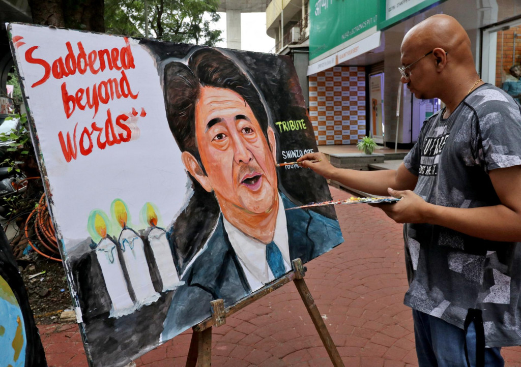 Umelec dokončuje obraz zavraždeného japonského expremiéra Šinzóa Abeho. FOTO: Reuters