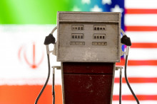 Model benzínového čerpadla pred farbami vlajky USA a Iránu.FOTO: REUTERS
