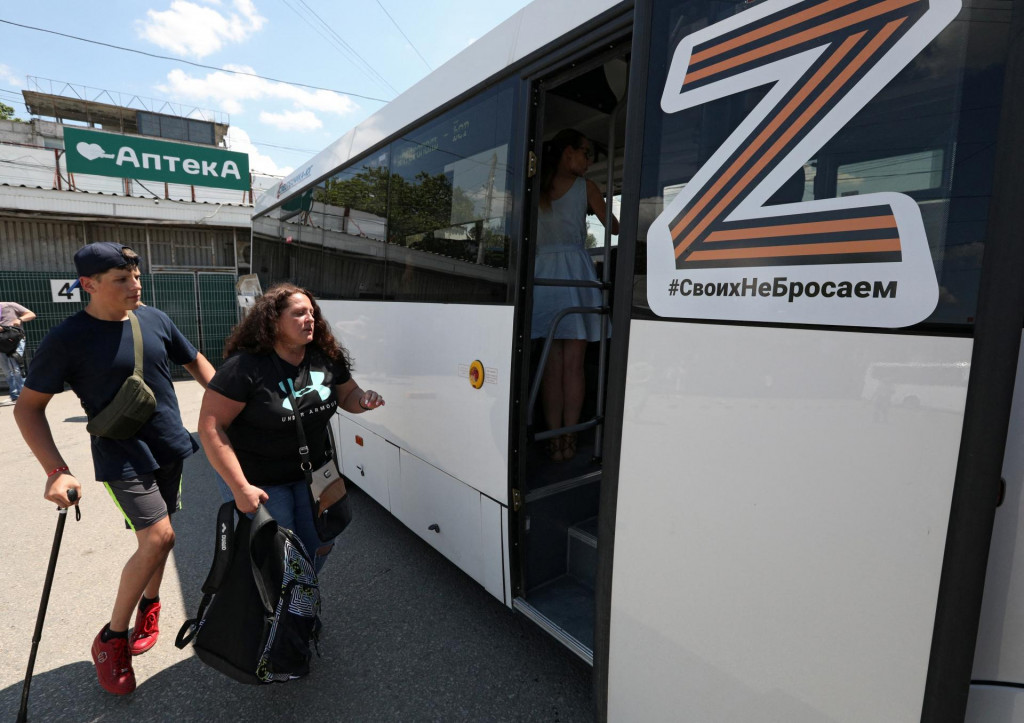 Ľudia nastupujú na autobusovej stanici v Simferopole na Kryme do autobusu, ktorý odchádza do ukrajinského mesta Berďansk pod kontrolou Ruska. FOTO: Reuters 