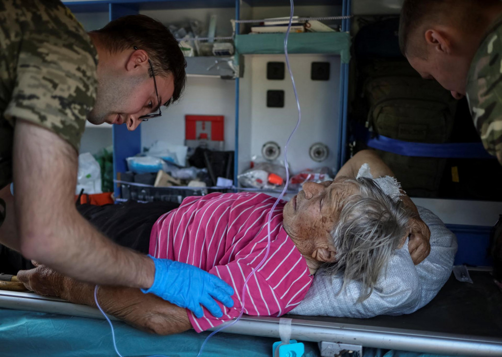 Ukrajinskí vojenskí zdravotníci ošetrujú obyvateľku Donbasu zranenú po ruskom útoku. FOTO: REUTERS