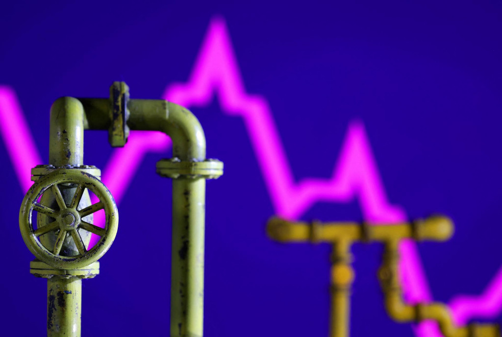 Model plynovodu a klesaj&uacute;ci akciov&yacute; graf. FOTO: REUTERS/Dado Ruvic