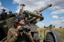 Ukrajinský príslušník armády kontroluje oblasť po streľbe z ťažnej húfnice FH-70 na frontovej línii. FOTO: Reuters