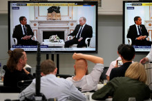 Novinári sledujú televízny prenos zo stretnutia ruského prezidenta Vladimira Putina s indonézskym prezidentom Jokom Widodom v Kremli v Moskve, Rusko 30. júna 2022. FOTO: REUTERS