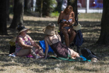 Ženy sa ukrývajú pred slnkom v chládku na kúpalisku Kuchajda počas letných horúčav v Bratislave. FOTO: TASR/Jaroslav Novák
