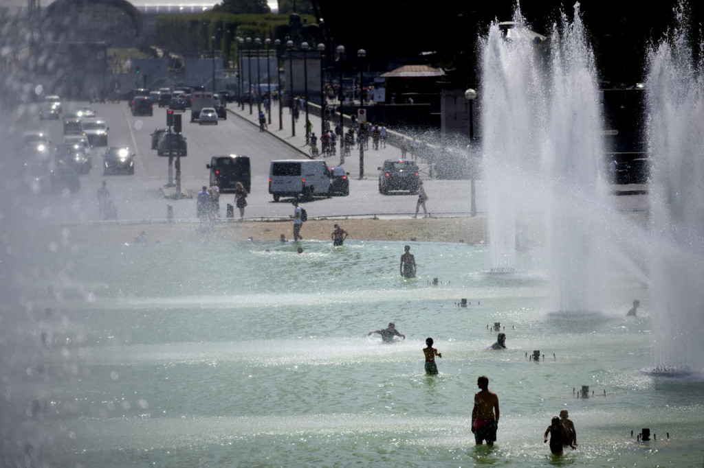 Ľudia sa osviežujú vo fontáne v záhradách Trocadero počas extrémnych horúčav v Paríži.