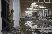 &lt;p&gt;Ukrajinský vojak sa pozerá na ruiny športového komplexu Národnej technickej univerzity v Charkove. FOTO: TASR/AP&lt;/p&gt;