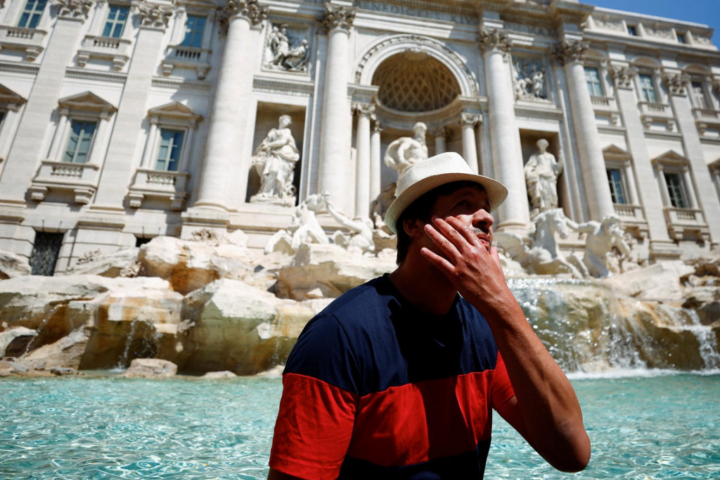 Muž sa ochladzuje pri fontáne di Trevi počas horúceho počasia, keďže Európu zasiahla vlna horúčav v Ríme, Taliansko, 19. júla 2022. FOTO: Reuters