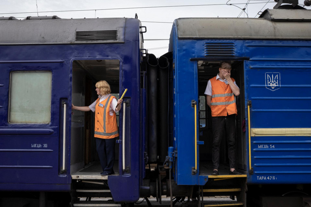 Robotníci stoja vo vlaku do Dnepra a Ľvova počas evakuácie civilistov z vojnou zasiahnutých oblastí východnej Ukrajiny, uprostred ruskej invázie do krajiny, v Pokrovsku, Donecká oblasť, Ukrajina, 25. júna 2022. FOTO: REUTERS