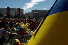 Ľudia kladú kvety na rakvu s telom Abdulkarima Gulamova, ukrajinského vojaka, ktorý bol zabitý v boji proti ruským jednotkám v Chersonskej oblasti 17. júla. FOTO: REUTERS