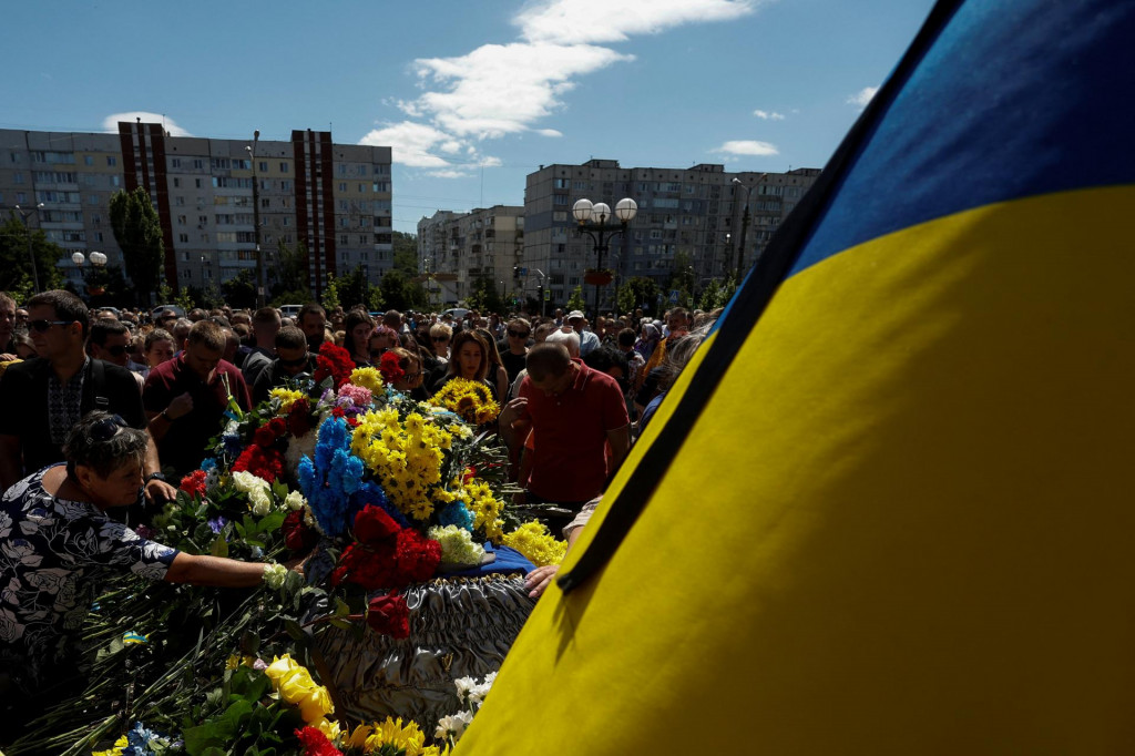 Ľudia klad&uacute; kvety na rakvu s telom Abdulkarima Gulamova, ukrajinsk&eacute;ho vojaka, ktor&yacute; bol zabit&yacute; v boji proti rusk&yacute;m jednotk&aacute;m v Chersonskej oblasti 17. j&uacute;la. FOTO: REUTERS