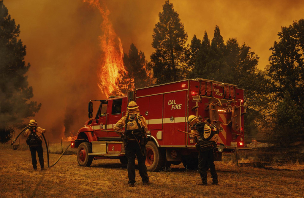 Hasiči sa pripravuj&uacute; na z&aacute;chranu stavby počas &scaron;&iacute;riaceho sa lesn&eacute;ho požiaru pri Yosemitskom n&aacute;rodnom parku. FOTO: TASR/AP