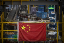 Čínska vlajka visí neďaleko linky na automatickú manipuláciu s balíkmi v sklade pre čínskeho internetového predajcu JD.com v Pekingu. FOTO: Mark Schiefelbein
