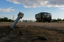 &lt;p&gt;Ruské vojenské nákladné auto prechádza okolo nevybuchnutej munície. FOTO: Reuters &lt;/p&gt;