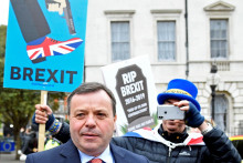 Britský podnikateľ a spoluzakladateľ kampane Leave.EU Arron Banks prechádza okolo demonštrantov proti Brexitu pred budovou parlamentu v Londýne. FOTO: Reuters