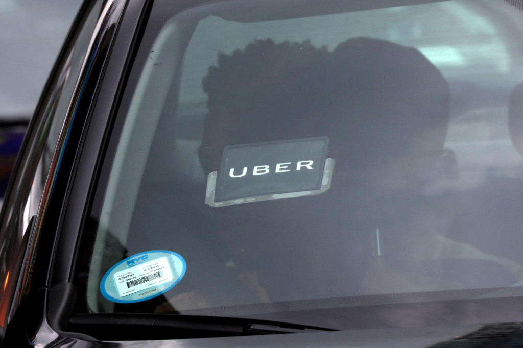 Logo Uberu na aute, ktoré prechádza cez Times Square v New York City, New York, USA, 27. júla 2018. FOTO: REUTERS