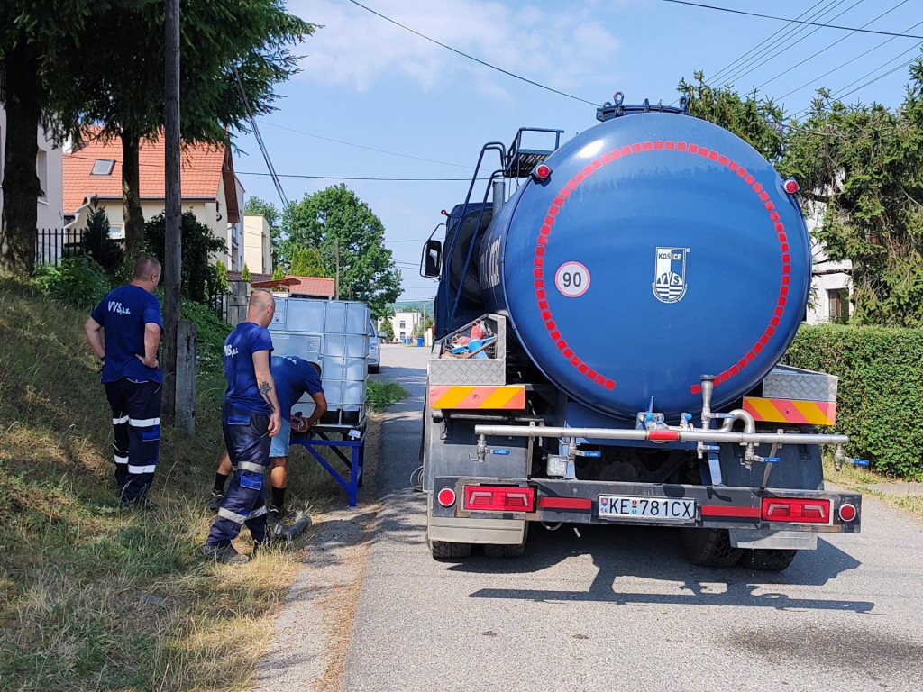 Pracovníci Východoslovenskej vodárenskej spoločnosti umiestňujú na uliciach v obci Ruskov nádrže s pitnou vodou. FOTO: TASR/Marián Holubčík