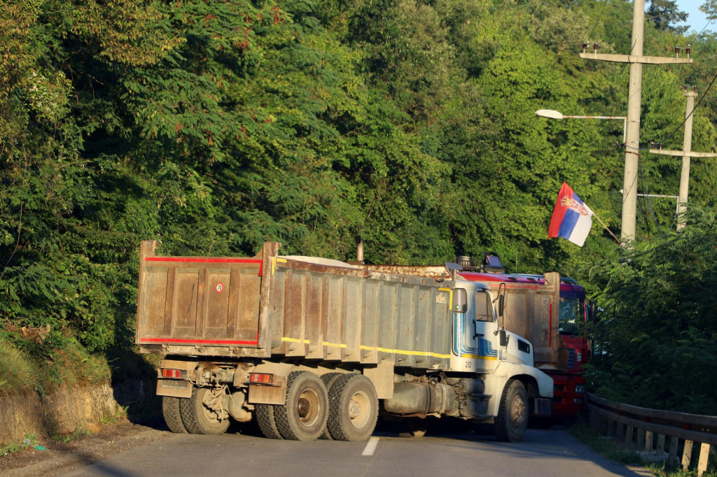 Srbská vlajka a kamión, ktorý blokuje cestu. FOTO: Reuters