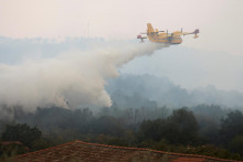 &lt;p&gt;Hasičské lietadlo nad lesným požiarom neďaleko hraníc s Talianskom pri pohľade zo slovinskej Kostanjevice.FOTO: Reuters&lt;/p&gt;