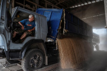 Zamestnanec vykladá pšeničné zrná v sklade v dedine Tomylivka na Ukrajine. FOTO: Reuters
