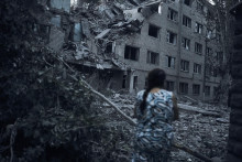 Ukrajinka kráča okolo trosiek budovy poškodenej pri nočnom bombardovaní v Mykolajive na juhu Ukrajiny. FOTO: TASR/AP