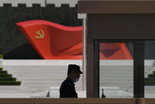 Strážnik stojí pri vlajke Komunistickej strany Číny v Múzeu Komunistickej strany Číny v Pekingu. FOTO: TASR/AP
