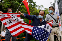 Pročínski demonštranti v Hongkongu trhajú vlajku USA. FOTO: Reuters